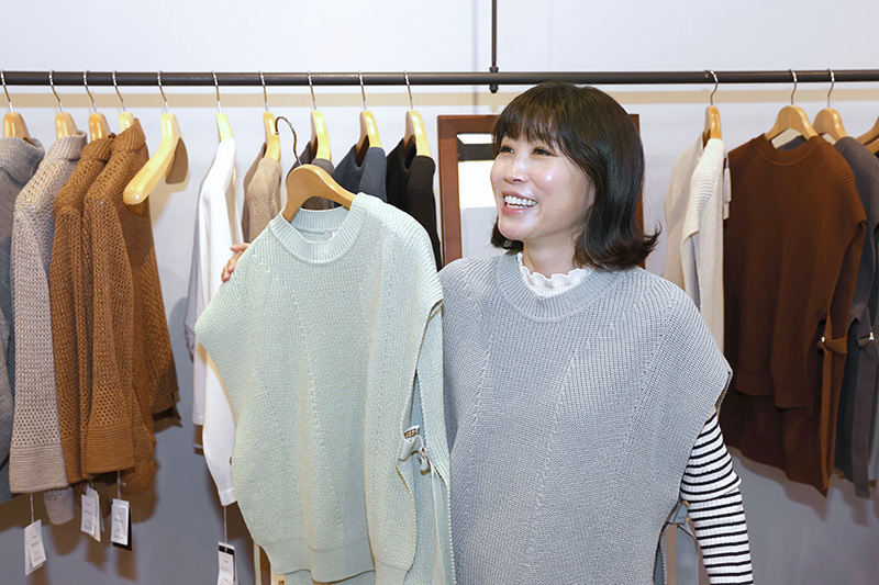 種類豊富なニットの中でお気に入りの1枚を探す水森かおりさん＝五泉市吉沢1