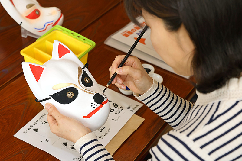 どんどん筆が進む水森さん。「目力があるなぁ」と愛着が湧いた様子だった＝阿賀町津川