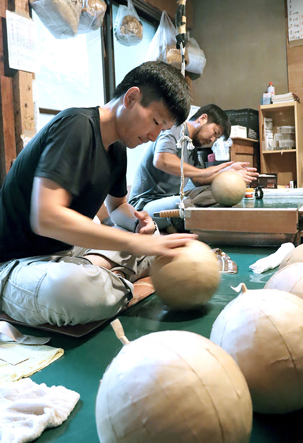 丁寧に花火を作っていく新潟煙火工業の花火師たち=7月中旬、新潟市西蒲区