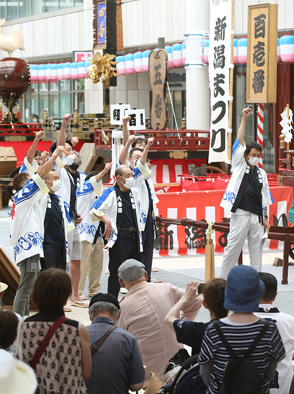 オープニングセレモニーで力強い木やりなどを披露した八番組のメンバーら=7月24日、新潟市中央区古町通7の古町ルフル広場