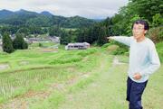 カタクリの群生でも知られる棚田を指し示す佐野誠五さん＝三条市北五百川