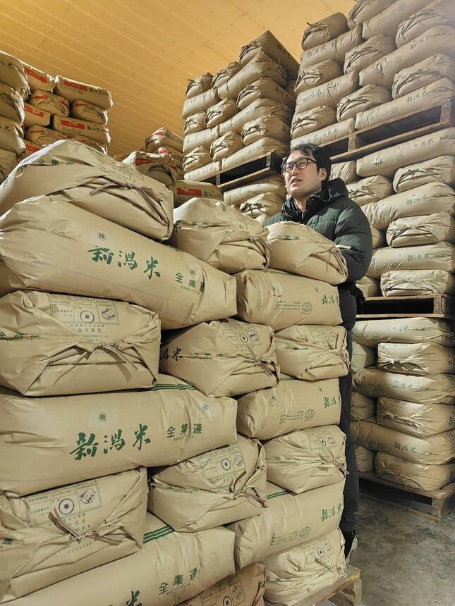 ２０２５年産米の在庫が積み上がった「高橋屋商店」の倉庫＝１月、新潟市西蒲区