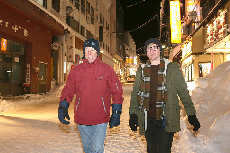 ほろ酔いで赤倉中央通りを歩くジェームズ・トムさん（右）とジムさん親子。花見や相撲など日本文化にも強い関心を寄せていた＝2月1日、妙高市赤倉