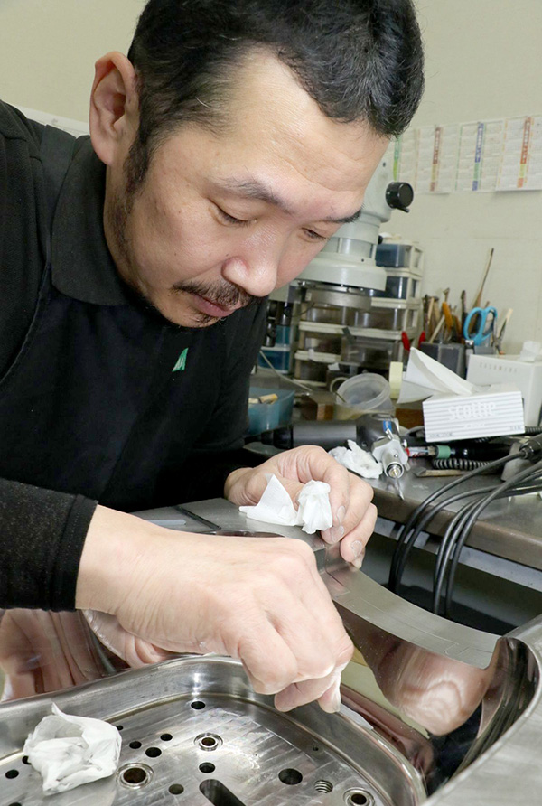 砥石で金型を磨く職人。時には千分の１ミクロン単位で磨き上げる