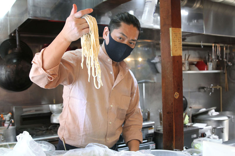 自慢の極太麺の出来栄えを確かめる「ジョニーの味噌」店主の佐藤幸樹さん＝東京都荒川区