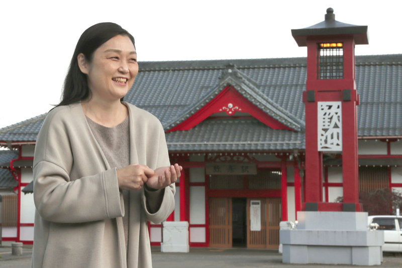 観光駅長を務めていた頃の思い出を語る遠藤麻理さん＝弥彦村弥彦のＪＲ弥彦駅前