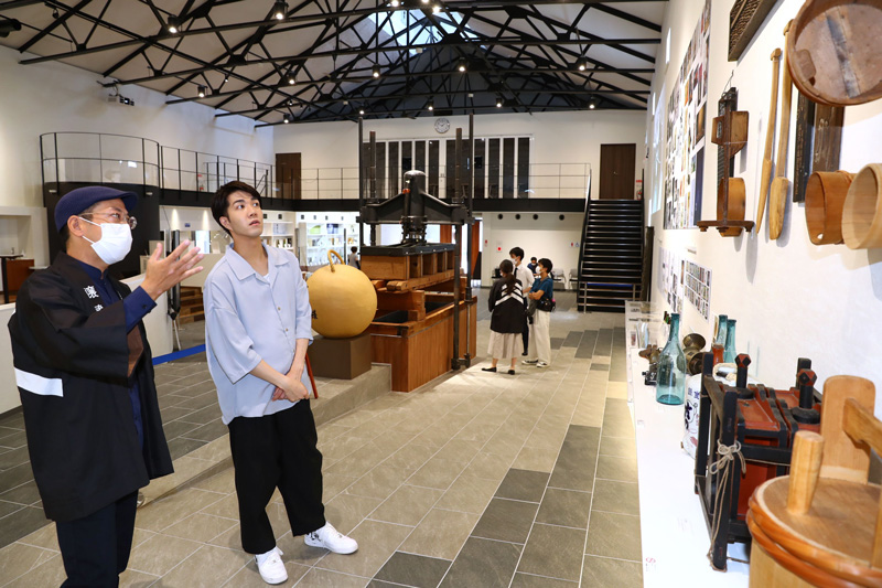 吉乃川の歴史や酒造りについて学べる「醸蔵」を見学する中澤卓也さん（右）＝長岡市摂田屋４