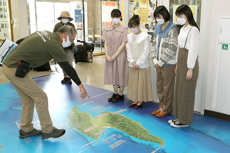 佐渡ジオパークセンターで池善世さんから説明を受けるRYUTist。センターには観光客や市民向けに展示や資料が用意されている＝佐渡市両津夷