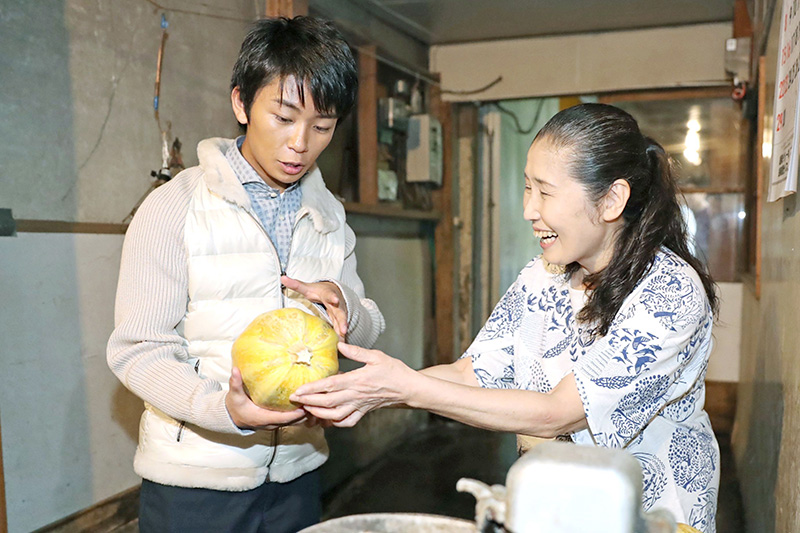 今成漬物店を訪れ大歓迎を受けた加藤さん＝南魚沼市六日町