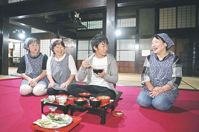 豪農の暮らしを今に伝える「目黒邸」で、郷土料理を味わう加藤さん＝魚沼市須原