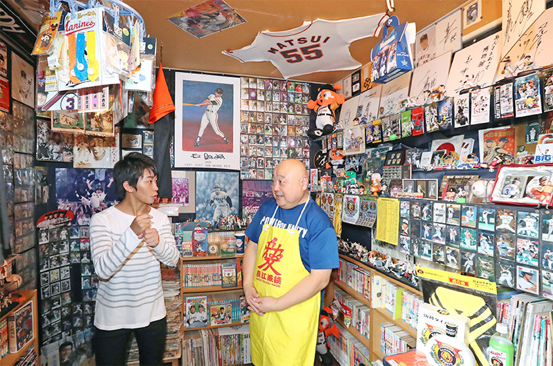 エリア８７８魚沼博物館でプロ野球グッズを集めたコーナー。阪神ファンの加藤さん（左）と盛り上がる桜井さん＝魚沼市青島