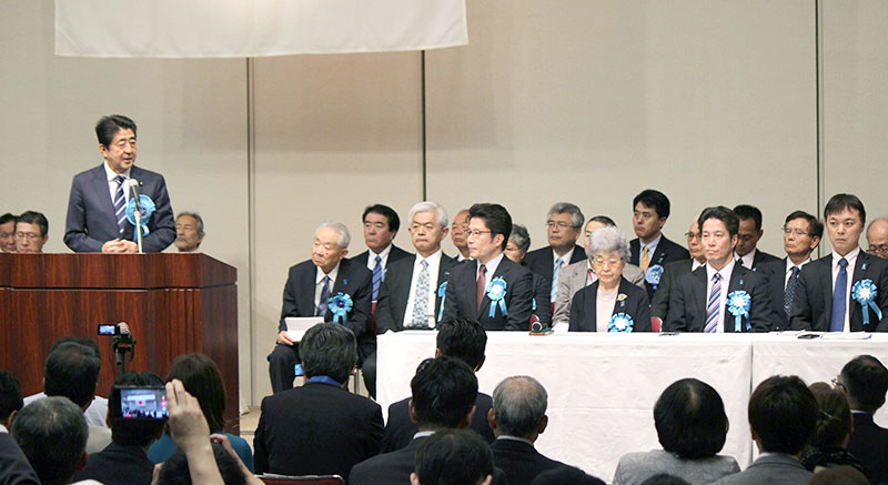 「国民大集会」で日朝首脳会談実現への意欲を語る安倍晋三首相（左）。拉致被害者や特定失踪者の家族らは硬い表情で聞き入った＝５月１９日、東京都